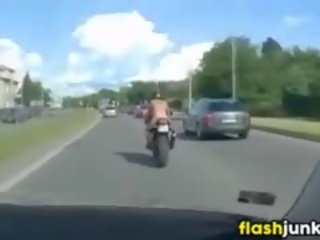 Telanjang dada bertato perempuan menunggangi sebuah motorcycle