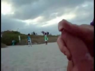 Amerikansk turist runkar på den strand medan kvinna passing av klämma