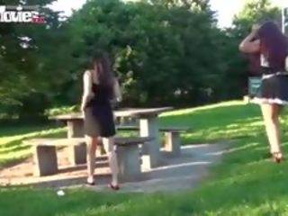 Kaks lesbid casually välklamp nende pussies sisse a avalik park