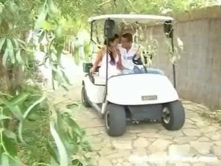 A young lady and her young man are driving around in a golep cart. suddenly they stop and the stripling leads to touch the prawan up,